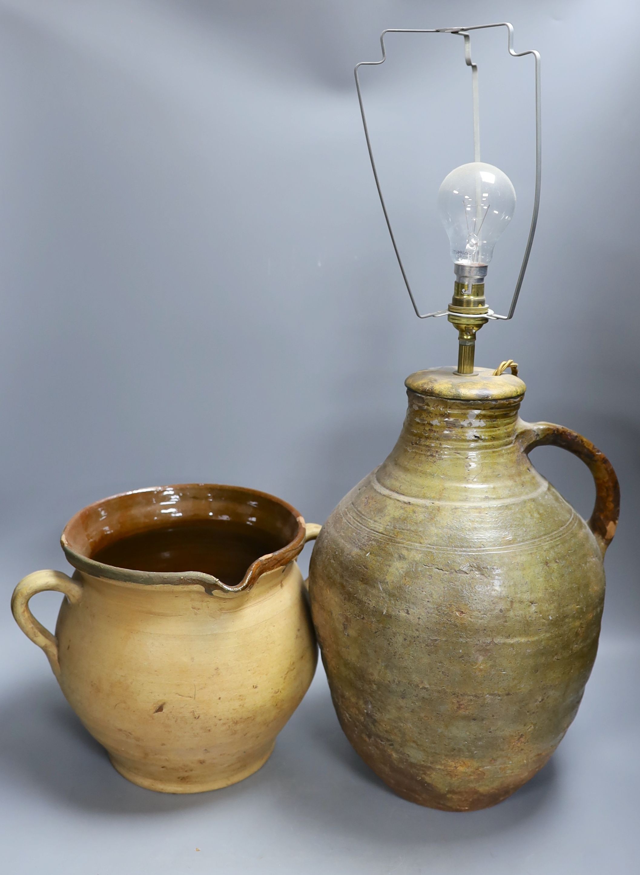A stoneware two handled jug and a table lamp base. Table lamp 37 cms high.